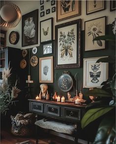 a living room filled with lots of framed pictures and candles on top of a table