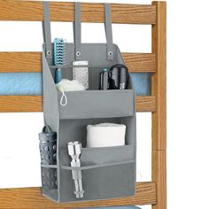 a gray bag hanging from the side of a bunk bed with items in it and toiletries inside