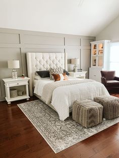 a large white bed sitting on top of a hard wood floor next to a window