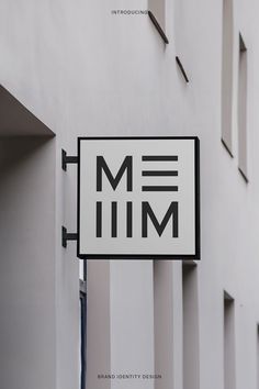 a white and black sign hanging from the side of a building