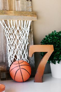 the number seven is next to a basketball and a potted plant in front of it