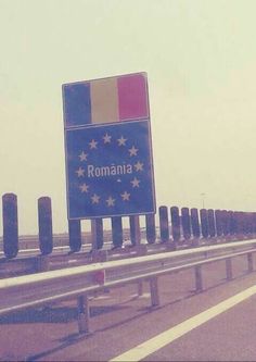 a road sign with the word roma on it in front of a line of poles