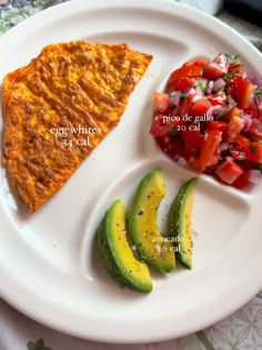 a white plate topped with two slices of pizza and sliced avocado