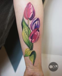 a woman's arm with three flowers on it and the word love written in cursive writing