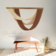 a wooden bench sitting in front of a wall hanging from it's side, next to a potted plant