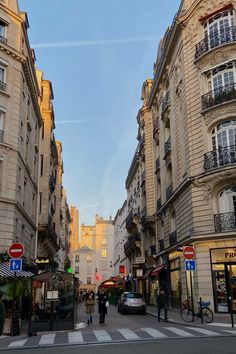 people are walking down the street in front of buildings