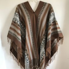 "This is a traditional heavy weight Andean poncho made by one of our most talented weavers. The natural fiber yarn is hand-dyed and woven into beautiful patterns and color arrangements. Perfect to keep you warm around ceremonial fires! There is yarn fringe at the bottom.  One size fits most adults. Unisex. Dimensions: 66\" x 44\" Peruvian woven textiles are incomparable in their quality and beauty. Add this to your collection today! We are a non-profit organization and proceeds from all sales go Handwoven Poncho Shawl For Festivals, Handwoven Festival Poncho Shawl, Bohemian Handwoven Shawl Poncho, Bohemian Woven Winter Shawl, Handwoven Brown Poncho For Winter, Artisan Handwoven Multicolor Poncho, Traditional Handwoven Poncho, Traditional Beige Poncho For Winter, Bohemian Alpaca Shawl One Size