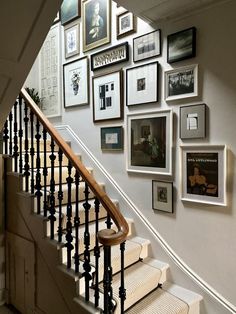 a staircase with many framed pictures on the wall