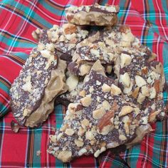 several pieces of chocolate and nuts on a plaid cloth