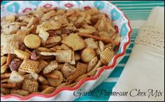 a bowl full of chex mix sitting on top of a blue and white table cloth