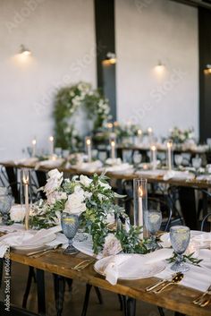 the tables are set with white flowers and candles for an elegant wedding reception or special event