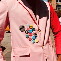 a man wearing a pink suit with buttons on it