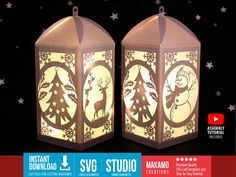 two lighted lanterns with reindeers and trees on them in front of snowflakes