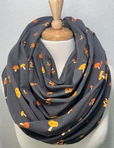 Who loves Mushrooms!!  This is a soft and cozy grey with orange mushrooms scarf that will keep you warm this season. This scarf is made of 100% soft cotton jersey that stretches a little. This is sewn as an infinity loop scarf that has no raw edges or open seams. You can wear this scarf several different ways as shown in the pictures.  Check out all the photos for some ideas.  We take pride in our handmade items and hope you enjoy them as much as we did making them.  Each item is from a smoke free home. Measurements: 13.5" wide ( 27" in diameter) 36" drop long ( 72" in diameter) 97% Cotton, 3% Spandex Washing Recommendations: Wash in cold on a delicate cycle, hang to dry. You can follow with a steamer or lightly iron with the steam on to get any wrinkles out. If you have any questions, ple Handmade Infinity Scarf For Fall, Cozy Multicolor One Size Scarves, Multicolor One-size Infinity Scarf For Fall, Handmade Multicolor Infinity Scarf One Size, Orange Mushroom, Casual Multicolor Scarf, One Size, Fall Scarves, Loop Scarf, Infinity Scarf