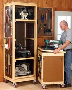 a man standing in front of a cabinet filled with tools