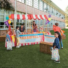 children are standing in front of a carnival booth