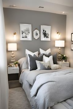 a bedroom with gray walls and white bedding, two framed pictures on the wall