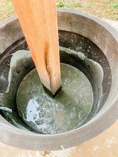 a bucket filled with water next to a wooden handle