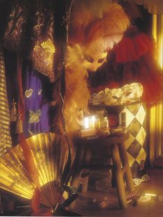 an assortment of decorative items displayed on a table with candles and fan in the foreground