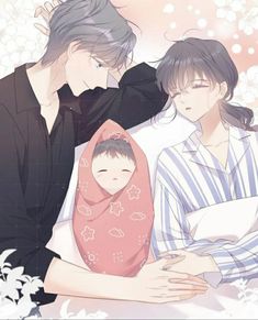 two people are holding a baby in their arms and one person is wearing a blanket