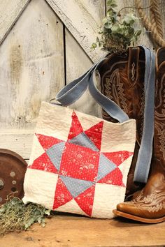 cowboy boots and a quilted tote bag sitting on a table