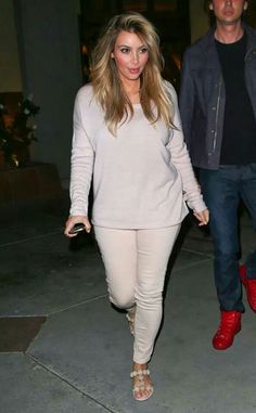 a man and woman are walking down the street at night, one is wearing red shoes