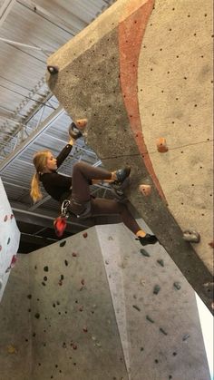 a woman climbing up the side of a rock wall