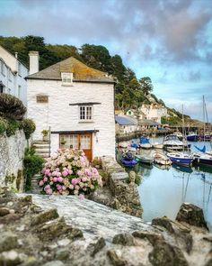 boats are parked in the water next to a white building with flowers growing out of it