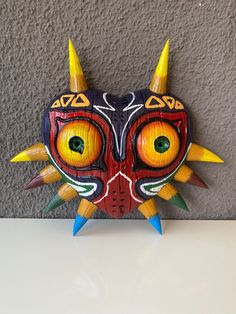 a wooden mask with yellow and green eyes