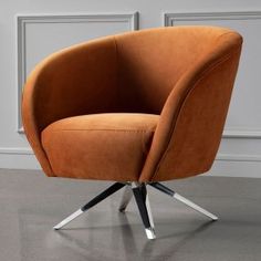 an orange chair sitting on top of a floor next to a white wall in a room