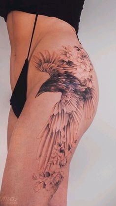 a woman's thigh with a bird tattoo on it