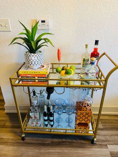 a bar cart filled with drinks and liquor bottles on top of a hard wood floor