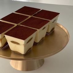 four desserts are arranged on a gold platter