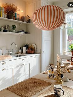 a kitchen filled with lots of white cabinets and counter top space next to a window