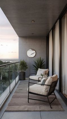 a balcony with a chair, plant and clock on the wall next to glass doors