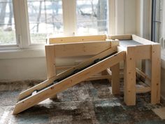 a child's wooden play set sitting on the floor in front of a window