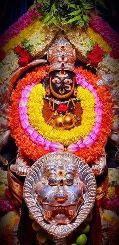 an idol is displayed with flowers and fruit