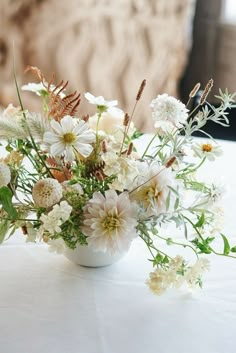 a vase filled with white flowers on top of a table