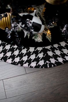 a black and white christmas tree skirt with gold ornaments on it's bottom layer