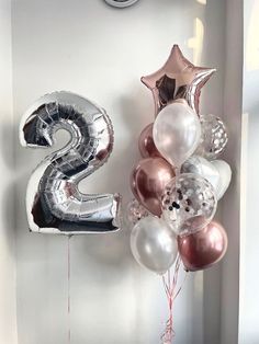 the number two balloon is hanging on the wall next to some balloons and streamers