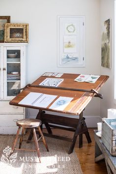 a wooden table sitting in the middle of a living room next to a chair and cabinet