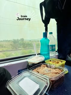 there are many containers with food on the table next to each other and water bottles