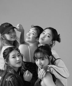 black and white photograph of four girls posing for the camera with their arms around each other