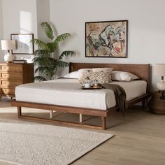 a bed sitting on top of a wooden frame in a bedroom