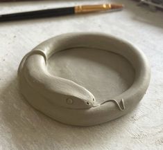 a close up of a ring on a table next to a pen and pencils