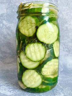 a jar filled with cucumbers sitting on top of a table