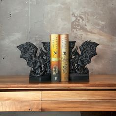 two bookends are sitting on top of a wooden table next to each other