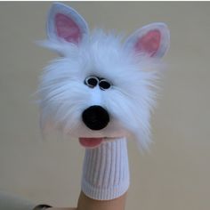 a person holding a fake white dog with big eyes on it's face and nose