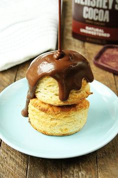 chocolate drizzled on top of two biscuits on a blue plate with a spoon