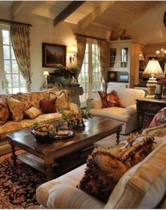 a living room filled with lots of furniture and pillows on top of it's couches